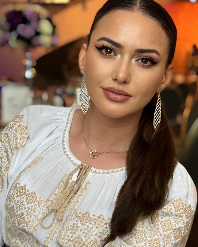 Ioana Balan în ie albă cu broderie aurie, cu părul strâns pe o parte