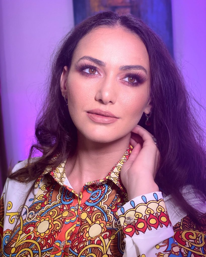 Portret al Ioanei Balan în lumină violet, într-o bluză cu imprimeu colorat